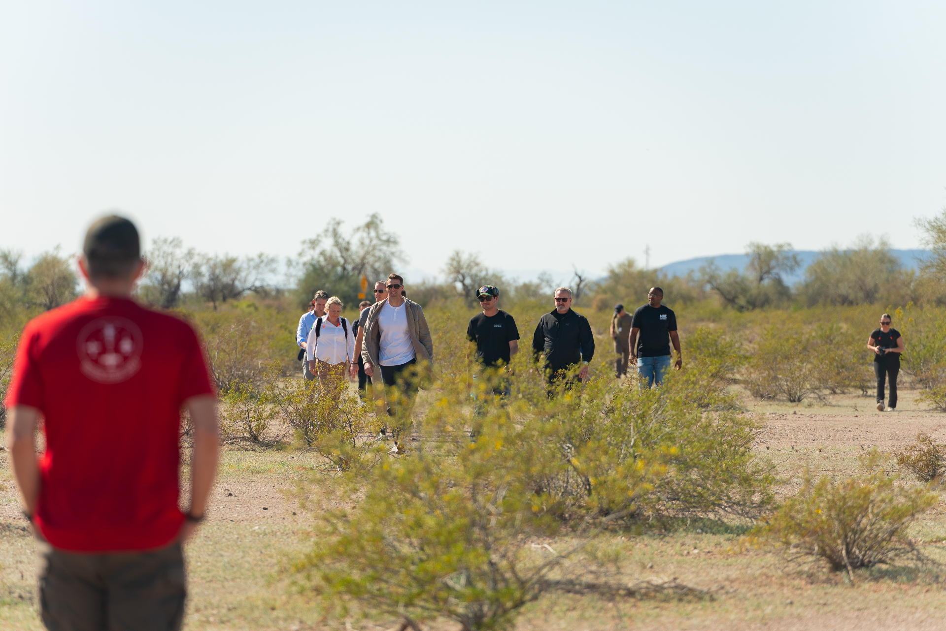 Attendees walking through the desert landscape